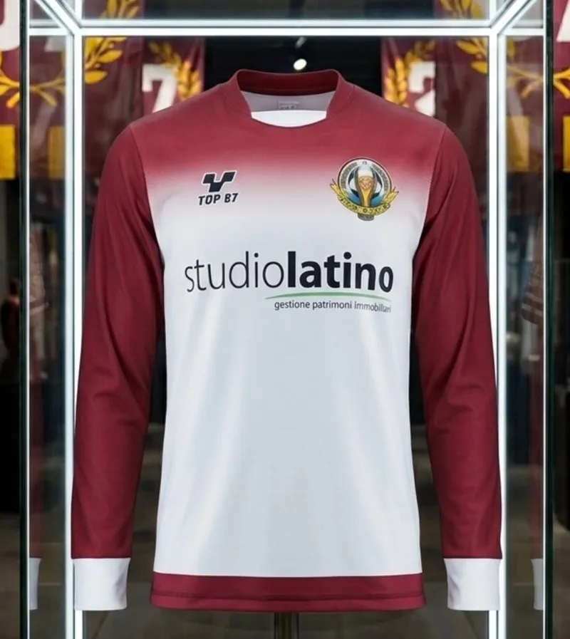 Maglia a maniche lunghe bianca, con spalle e maniche granata e lo sponsor Studio Latino.