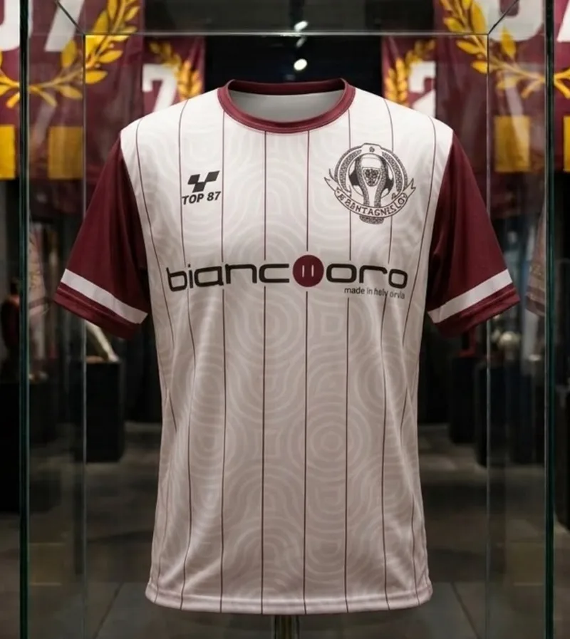 Maglia bianca a righe sottili granata, con colletto e maniche granata e lo sponsor Biancooro.