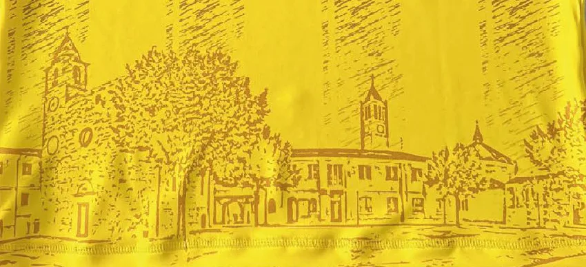 Dettaglio di una maglia gialla con il disegno della piazza del paese stampato in color granata.