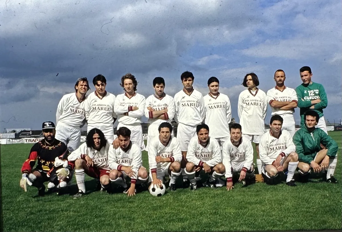 Foto di squadra in maglia bianca, con i due portieri in maglia scura e verde.