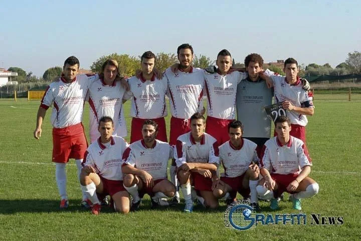 Foto di squadra in maglia bianca e pantaloncini rossi; il capitano regge un cartello con il numero 20.